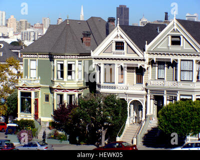 Questa fotografia cattura le iconiche signore dipinte di San Francisco, case in stile vittoriano situate vicino ad Alamo Square. Queste case storiche sono riconosciute per la loro architettura distintiva e i colori vivaci. Foto Stock