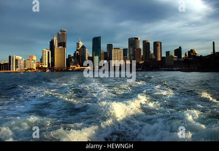Lo skyline di Sydney, visibile dai traghetti che viaggiano verso le isole vicine, offre viste iconiche dei moderni grattacieli e la bellezza naturale del porto di Sydney. Questa combinazione di architettura urbana e canali panoramici è un segno distintivo del paesaggio della città, offrendo prospettive uniche sia per le sue caratteristiche storiche che per quelle contemporanee. Foto Stock
