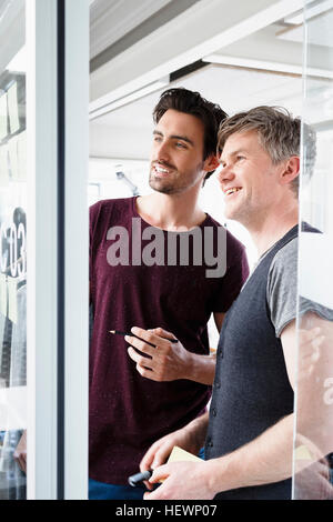 Colleghi il brainstorming, sorridente Foto Stock