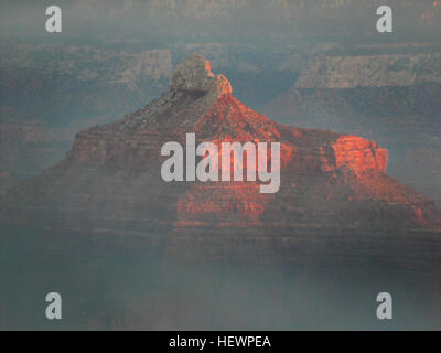 Questa fotografia cattura la vista mozzafiato del Grand Canyon durante il tramonto. Scattata in un tour al tramonto del Grand Canyon, l'immagine mostra le spettacolari formazioni rocciose del canyon e i colori vivaci durante l'ora d'oro, evidenziando la bellezza naturale di questo sito patrimonio dell'umanità dell'UNESCO. Foto Stock