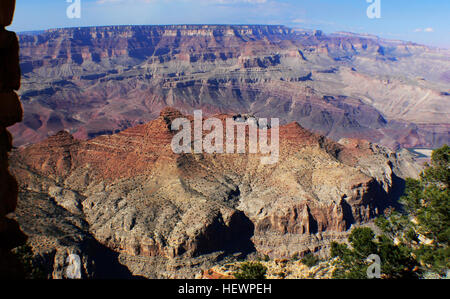 Questa fotografia cattura una vista mozzafiato del Grand Canyon, mostrando l'iconico South Rim. Scattata con una macchina fotografica sul ponte, l'immagine evidenzia la vastità del canyon e le intricate formazioni geologiche durante un bellissimo tramonto, offrendo una scena perfetta per le visite turistiche. Foto Stock