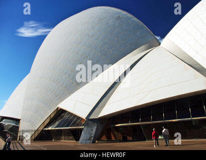 Questa immagine presenta l'iconica Sydney Opera House, progettata dall'architetto Jorn Utzon, che mostra il suo unico tetto a "vele bianche". La scena mette in evidenza anche altri punti di riferimento di Sydney, luoghi di arti dello spettacolo e meraviglie architettoniche, tra cui il Joan Sutherland Theatre e l'acqua specchio di Louis Kahn. Foto Stock