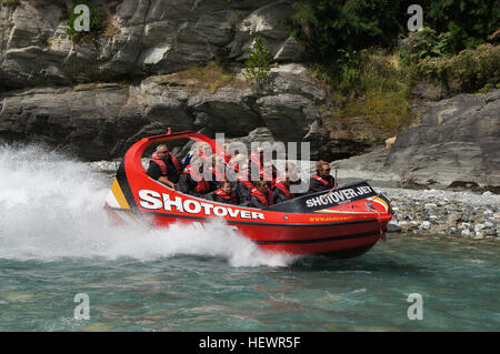 Dal momento in cui l'acceleratore colpisce il pavimento, la vostra adrenalina colpisce il tetto come lei velocità in pochi centimetri di acqua lungo il famoso fiume Shotover e profondo nella spettacolare fiume Shotover Canyon. Si tratta di un incredibile acqua bianca ride, come il Canyon Shotover torre pareti sopra di voi, il vostro esperto conducente mette il 'Big Red' Jet Boat attraverso i suoi ritmi e sapientemente fruste passato affioramenti rocciosi, sfiora intorno a balze e massi e velocità attraverso la drammatica e stretti canyon. Facce rocciose sfocatura nella vostra visione periferica e gli spruzzi di acqua in miriadi di acqua bianco cristalli con ogni volta come Foto Stock