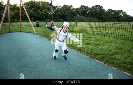 Ritratto di ragazzo in costume da astronauta tirando il parco giochi filo zip Foto Stock