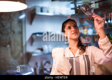 Proprietario del ristorante controllo bicchiere da vino in cucina Foto Stock