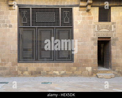 Facciata (finestra Mashrabiya e aprire la porta di legno sul muro di pietra) di Beit (casa) El Harrawi, un vecchio Mamluk epoca storica casa nel borgo medievale di Cairo, Egitto Foto Stock