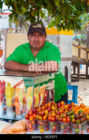 L'uomo la vendita di frutta fresca da uno stallo sulla Quinta Avenue, Playa del Carmen e Riviera Maya, Messico Foto Stock