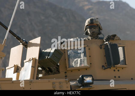 Provincia di Kapisa, Afghanistan - un membro di Kapisa Provincial Reconstruction Team continua a vegliare su di un combinato-smontato pattuglia di PRT e Afghanya manutenzione stradale i membri del team dalla torretta del suo veicolo qui 1 dic. Il RMT è stato addestrato dal PRT e consente di proteggere la zona dai ribelli. La missione di Kapisa PRT è quello di agevolare gli enti locali e i governi nazionali dell'Afghanistan a lavorare insieme per contribuire a fornire per lo sviluppo e le esigenze di sicurezza della popolazione afghana. (Foto di U.S. Air Force Staff Sgt. Kyle Brasier, Kapisa Provincial Reconstruction Team / rilasciato) Flickr - Foto Stock