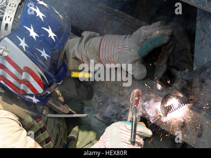 041113-M-1250B-007 Lutafiyah, Iraq (nov. 13, 2004) - STATI UNITI Navy Seabee assegnato al ventiquattresimo Marine Expeditionary Unit (MEU), gode di due pezzi di metallo insieme con un colpo-torcia come egli aiuta a riparare un ponte in Lutafiyah, Iraq. Il ponte fu gravemente danneggiato in ripetuti attacchi da parte di anti-militanti iracheni. Il ventiquattresimo MEU sta conducendo le operazioni di sicurezza e di stabilità nel nord della provincia di Babele o Iraq. Stati Uniti Marine Corps photo by Lance Cpl. Sarah A. castori (rilasciato) Navy US 041113-M-1250B-007 U.S. Navy Seabee assegnato al ventiquattresimo Marine Expeditionary Unit (MEU), sguaina due pezzi Foto Stock