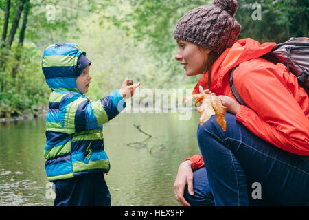 Madre e figlio di esplorare in streaming in foresta, Vancouver, British Columbia, Canada Foto Stock