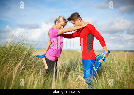 Matura in erba alta su una gamba facendo esercizi di stretching Foto Stock