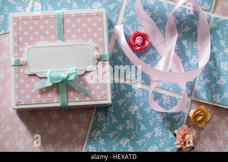 Vista aerea di scatola regalo, nastro e fiori di carta Foto Stock