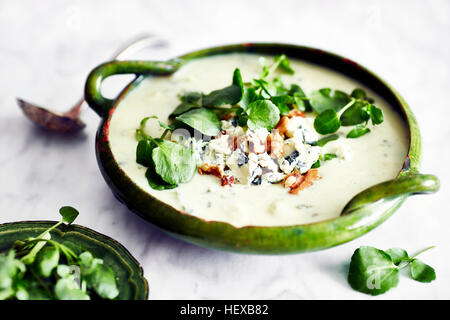 Ciotola di zuppa guarnita con formaggio blu, noce e crescione Foto Stock