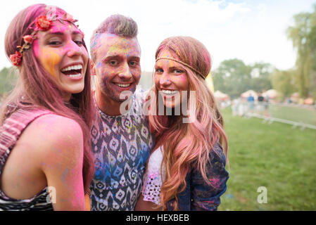 Gruppo di amici al festival, coperto di polvere colorata vernice Foto Stock