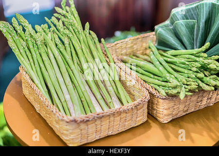 Mazzetti di asparagi su uno sfondo di legno. Foto Stock