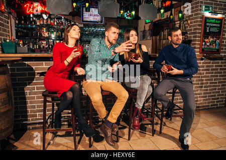 Gruppo di amici godendo di bere insieme in bar Foto Stock