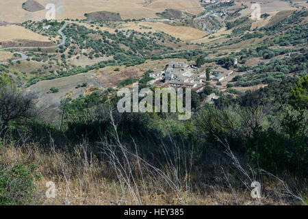 Paesaggi della Sicilia centrale in estate. Con la tipica siciliana di colline e ulivi, con una strada che si snoda attraverso le montagne. Foto Stock