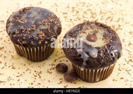 Cioccolato muffin alla vaniglia cosparso con cioccolato in polvere Foto Stock