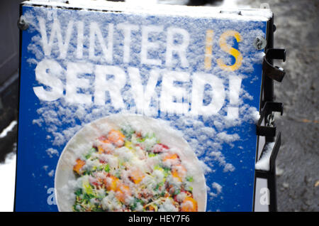 Neve e ghiaccio coprire un ristorante della lettura del segno 'inverno è servita!' Foto Stock