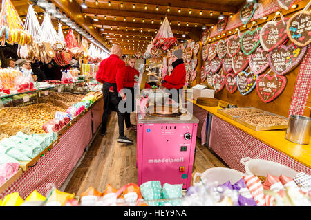 Persone che serve a dolci stallo a un Tedesco mercatino di Natale di Alexanderplatz di Berlino. Foto Stock