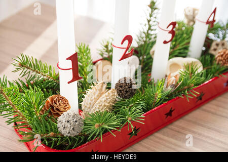 Natale corona di Avvento closeup con decorazione su tavola, primo avvento candela in focus Foto Stock