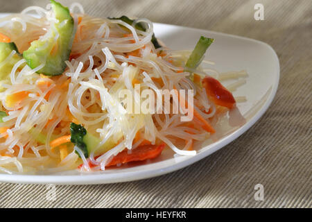 Funchoza insalata con le verdure su una piastra bianca Foto Stock