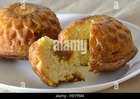 Due muffin su una piastra bianca con un ripieno Foto Stock