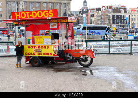 Una piccola ragazza in piedi di fronte ad un Hot Dog contatore mobile in Olanda, Amsterdam, Paesi Bassi. Foto Stock