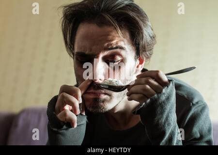 Addict in depressione odori cocaina da un cucchiaio Foto Stock