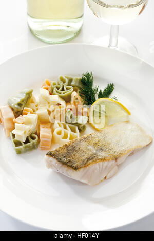 Piatto di frutti di mare: filetto di luccioperca con pasta e aneto insalata e vino bianco Foto Stock