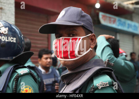 Dacca in Bangladesh. 24 dicembre, 2016. Bangladesh dei funzionari di polizia stand alert sulla scena di un'operazione di tempesta un presunto militante nascondiglio in Dhaka sul dicembre 24, 2016 come un team dall'unità di lotta contro il terrorismo di Dhaka Metropolitan Police cordoned fuori da un edificio di tre piani nella capitale. Due militanti femmina lungo con due bambini si arrese ai poliziotti, 1 femmina e un militante teen si sono uccisi durante il raid della polizia per esplosione di giubbotto suicida al di fuori della loro den mentre agiscono per arrendersi alla cop. © Monirul Alam © Monirul Alam/ZUMA filo/Alamy Live News Foto Stock