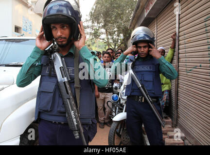 Dacca in Bangladesh. 24 dicembre, 2016. Bangladesh dei funzionari di polizia messo sul casco presso la scena di una operazione di tempesta un presunto militante nascondiglio. Dacca Metropolitan Police cordoned fuori da un edificio di tre piani nella capitale. Due militanti femmina lungo con due bambini si arrese ai poliziotti, 1 femmina e un militante teen si sono uccisi durante il raid della polizia per esplosione di giubbotto suicida al di fuori della loro den mentre agiscono per arrendersi alla cop. © Monirul Alam/ZUMA filo/Alamy Live News Foto Stock