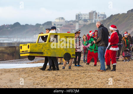 Bournemouth, Dorset, Regno Unito. 25 Dic 2016. Giorno di Natale 25 dicembre 2016. Tuffo bianco di Natale a Boscombe, Bournemouth, Dorset, Regno Unito. Coraggiosi volontari si tuffano nel freddo mare agitoso per una nuotata, per la nona nuotata annuale di Natale mattina, vestiti con costumi di fantasia e raccogliere soldi per Macmillan cura locale a Christchurch, una Specialist Palliative Care Unit per i pazienti nella comunità locale. Centinaia di persone partecipano all'evento che è diventato una tradizione popolare per molti prima del pranzo. © Carolyn Jenkins/Alamy Live News Foto Stock