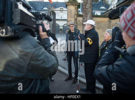 Stuttgart, Germania. 27 Dic, 2016. Daniel Kartmann parla ai giornalisti e il portavoce del Ministero di Stato accanto a Dietrich Wagner e il suo compagno di vita Erika Wagner al di fuori del Ministero di Stato di Stoccarda, Germania, 27 dicembre 2016. Kartmann subì gravi chirurgia oculare per una retina distaccata da un flusso di acqua su 'nero Giovedi' e Wagner è quasi cieco. Foto: Lino Mirgeler/dpa/Alamy Live News Foto Stock