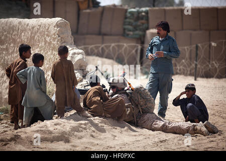 Ragazzi afghani curiosamente osservare U.S. Lancia Marine Cpl. Alexander Johnson, un rifleman con il quarto plotone, Kilo Company, 3° Battaglione, 3° Reggimento Marine, e 20-anno-vecchio nativo di Bayard, Neb., mentre Johnson e marines forniscono sicurezza su una pattuglia ha collaborato con la polizia nazionale afgana durante il distretto di Garmsir comunitari alle elezioni del consiglio qui, 17 aprile 2012. Durante la Afghan-led elezioni nella provincia di Helmand Garmsir del distretto, gli anziani del villaggio hanno rappresentato per oltre 2.200 voti per riempire 34 sedi DCC. Circa 200 membri delle forze di sicurezza nazionali afgane ha lavorato per fissare il Foto Stock