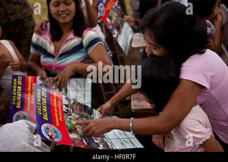 PUERTO PRINCESA, Palawan Repubblica delle Filippine - una donna locale legge un calendario che evidenzia l'esercizio Balikatan 2012 (BK12) ha passato fuori dalle forze armate delle Filippine esercito di soldati e militari degli Stati Uniti i membri del servizio a Santa Cruz Scuola Elementare, 24 aprile 2012. BK12 è un bilaterale annuale di esercizio che lavora per costruire le forze armate delle Filippine e militare degli Stati Uniti di pianificazione congiunta, le operazioni di emergenza e assistenza umanitaria funzionalità. BK12 consiste di tre eventi che comprendono una serie di aiuti umanitari civica progetti di assistenza che ha avuto inizio nel marzo 2 Foto Stock