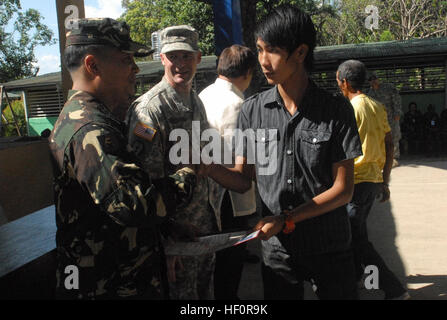 Mark Anthony Bartolome (a destra), 17, riceve il suo certificato di completamento in carpenteria e muratura Corso tenuto presso Callos Scuola Elementare di Penaranda, Nueva Ecija, Filippine, 25 Aprile dall esercito filippino Col. George Patrick V. Avila (sinistra), combinato di forze armate, comandante delle forze armate delle Filippine. AFP e soldati statunitensi che partecipano in esercizio Balikatan 2012 integrato il corso per volontari locali in una comunità le relazioni progetto coordinato con la scuola. Dopo la laurea del corso, ogni volontario ha ricevuto un sacco con tutti gli strumenti necessari, insieme con il materi Foto Stock