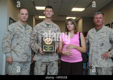 MARINE CORPS AIR STATION CHERRY POINT, N.C. - (Da sinistra a destra) Col. Andrew più corta, il comandante della Marina Gruppo di aeromobili 14, Cpl. La Giordania Freking, un Marine Air-Ground Task Force planner con MAG-14, Rebekeh Freking e Col Philip Zimmerman, il comandante della Marine Corps Air Station Cherry Point, premio Freking il Cherry Point Atleta dell'anno, 29 giugno. Il 22-anno-vecchio, Le Mars, Iowa native, finito nella top 400 in Marine Corps Marathon nel 2010, ha mantenuto un elevato Marine Corps fisica test di fitness e corse in più di 40 gare soltanto nel 2011. Una corsa per il tuo m Foto Stock