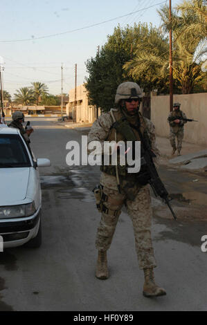 AR RAMADI Iraq (22 luglio 2005) - Caporale Kelly P. Baker, un fuciliere e team leader con la seconda squadra, primo plotone, la società C, 1° Battaglione, quinto reggimento Marine, utilizza la sua radio per parlare con i suoi compagni di Marines durante una pattuglia di recente nella città qui Luglio 22. Baker è una terza generazione di indiani americani in servizio nelle Marine Corps durante un tempo di conflitto. Il 21-anno-vecchio dal nuovo comune - una città all'interno di Ft. Berthold Indian Reservation in North Dakota - è discendente di affiliated Great Plains tribù Mandan, Hidasta Arikara e. Suo nonno, Clyde Baker, servito durante la II Guerra Mondiale e combattuto in th Foto Stock