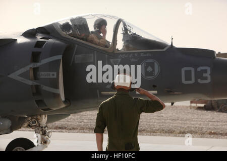 Lancia Cpl. Harrison York, un AV-8B Harrier II Plus manutentore con Marine squadrone di attacco 211, terzo aeromobile Marina Wing (avanti), saluta il cap. Stephen WHITE, Harrier pilota, come egli taxi a Camp Bastion, Afghanistan, flightline, Sett. 26. Il velivolo porta il nome di Lt. Col. Christopher Raible, lo squadrone di comandante che è stato ucciso durante un attacco al Camp Bastion airfield, Sett. 14. Superiorità aerea E28093 Harriers continuare le operazioni su Helmand 120926-M-ZM862-002 Foto Stock