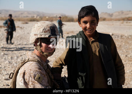 Stati Uniti Marine Corps 1Lt. Thomas Corbin, un responsabile della logistica assegnati alla polizia Advisory Team 4 (PAT-4), interagisce con un locale ragazzo afgano ad un Afgano poliziotto in uniforme (AUP) checkpoint nel distretto di Kajaki, provincia di Helmand, Afghanistan, Dicembre 2, 2012. I marines di PAT-4 hanno lavorato insieme con l'AUP per migliorare le operazioni di sicurezza e aumentare la stabilità dell'area. (U.S. Marine Corps foto di Cpl. Alejandro Peña/RILASCIATO) Polizia Advisory Team 4 121202-M-YH552-218 Foto Stock