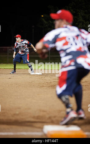 Army Sgt. Matteo Kinsey (sinistra) e i pensionati lancia Marine Cpl. Tim Horton (a destra), mutilati e membri del guerriero ferito amputato Softball Team, si dipartono delle loro basi durante una partita contro Honolulu Veterans Affairs presso la centrale di Oahu Softball complesso in Waipahu, Hawaii, Gen 9, 2013. Kinsey, 27, nativo di Rockville, Ind. ha perso il suo piede destro mentre in servizio in Afghanistan, Giugno 2, 2010. Horton, 28, nativo di San Antonio, Texas, ha perso parte della sua gamba sinistra quando il suo Humvee colpito una improvvisata dispositivo esplosivo a Ramadi, Iraq, Febbraio 5, 2005. La vita senza un arto è illimitato 130109-M-MM918- Foto Stock