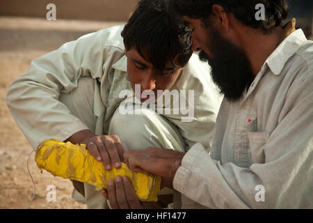 Afghan poliziotti locali guardare un nozionale esplosivi improvvisati componente del dispositivo durante la formazione con i compagni di forze di sicurezza nazionali afgane nella provincia di Farah, Afghanistan, 11 genn. 2013. Forze di sicurezza nazionali afgane sono state prendendo il filo nelle operazioni di protezione, con le forze della coalizione hanno come guide, per portare la sicurezza e la stabilità al popolo della Repubblica islamica dell'Afghanistan. (U.S. Marine Corps foto di Sgt. Pete Thibodeau) ANSF contro la minaccia IED 130111-M-BO337-119 Foto Stock