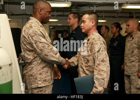 Hospital Corpsman 2a classe Wendell Tabios scuote le mani con Hospital Corpsman Chief Petty Officer Emmanuel B. Essienete, senior leader arruolato, entrambi con elemento di comando, xv Marine Expeditionary Unit, durante una cerimonia di premiazione organizzata in nave la struttura medica, 20 aprile. Xv MEU è distribuito come parte di Peleliu anfibio gruppo pronto ed è composta di circa 2.400 marines e marinai. Insieme con lo squadrone anfibio tre, forniscono una distribuita, mare flessibile a base di aria marina terreno Task Force in grado di condurre una ampia varietà di operazioni che vanno dall'uomo Foto Stock