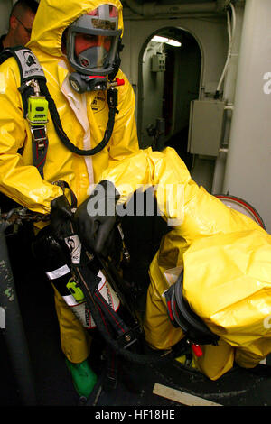 A bordo della USS ESSEX - Cpl. Alan R. Largen, un enhanced chimici, biologici, radiologici e nucleari membri del team con il trentunesimo Marine Expeditionary Unit, aiuta a un altro membro del team verso il basso una berlina qui nov. 14, durante una tre giorni a bordo di formazione ECBRN esercizio. Aggiungere un tocco di realismo alla formazione, molto dell'esercizio è stato effettuato dai membri piena di indossare indumenti di protezione, come ad esempio auto-contenuto apparecchi di respirazione, acciaio-toed boots, indumenti di protezione e guanti di gomma per rendere il movimento in tutta la nave più difficile. Il team ha dovuto camminare attraverso passaggi stretti, squeeze a Foto Stock