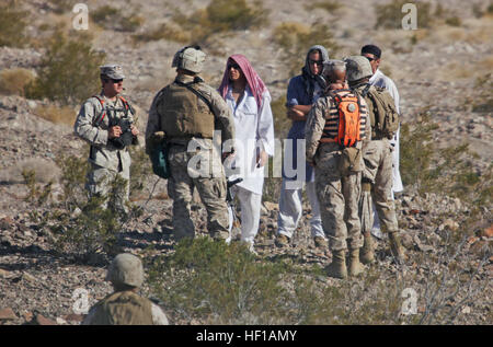 Marines con il combattimento il battaglione della logistica 6, seconda Marine Logistics Group, interagire con i lettori di ruolo mentre si conduce una lotta contro la pattuglia logistica a ventinove Palms, California, 4 giugno 2013. I marines Scambiate doni di cibo e di acqua durante la creazione di un rapporto con gli attori in posa come stranieri in preparazione per il battaglione di distribuzione per sostenere l'Operazione Enduring Freedom. Passare il tempo, CLB-6 finiture ITX nel deserto di Mojave 130605-M-ZB219-287 Foto Stock