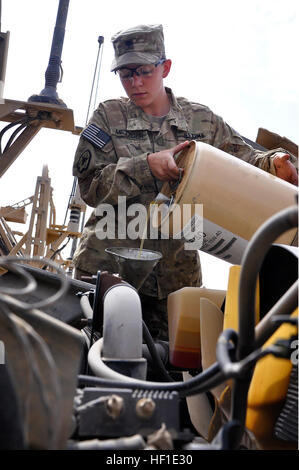 Spc. Michelle Metzger, un motore di trasporto con operatore 1487th Transportation Company, Ohio Army National Guard, si aggiunge olio nel suo veicolo a base multinazionale - Oggi Tarin Kot, Afghanistan, Agosto 12, 2013. Metzger, una miniera resistente imboscata veicolo protetto driver, esegue la manutenzione quotidiana sul veicolo e ha guidato circa 3.000 miglia nel suo primo schieramento in Afghanistan. (U.S. Esercito nazionale Guard foto di Sgt. Jessi Ann McCormick) 3.000 miglia in Afghanistan 130812-Z-FS372-444 Foto Stock