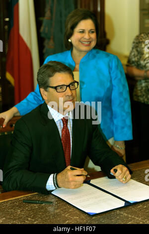 Texas Gov. Rick Perry si prepara a segno ceremoniously Senate Bill 162 al Campidoglio dello Stato del Texas in Austin, Agosto 28, 2013. Il Bill è autore, Stato Sen. Leticia Van de Putte (SD-26), è in piedi dietro Perry. (U.S. Air National Guard photo by Staff Sgt. Phil Fontana/RILASCIATO) Perry e Van de Putte Foto Stock