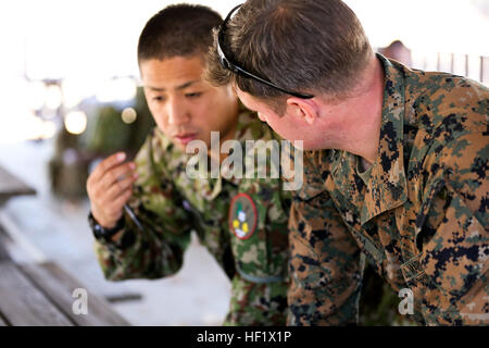 Un U.S. Marine, diritto, pre-sniper istruttore, Divisione scuole, discute di logistica con un soldato dal Giappone terra Forza di Autodifesa durante la conduzione di navigazione terrestre della formazione durante la fase di esercizio del pugno di ferro 2014 a bordo di Camp Pendleton, California, 22 gennaio 2014. Pugno di Ferro è un esercizio di anfibio che riunisce i Marines e marinai dal XV Marine Expeditionary Unit, altri mi Marine Expeditionary unità di forza, e i soldati della JGSDF, per promuovere l interoperabilità militare e levigare i singoli e le piccole unità di competenze attraverso impegnativo, complessa e un addestramento realistico. (U.S. Marine Corps ph Foto Stock