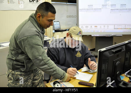 Sgt. Rodolfo Navarro, 1452nd combattere attrezzature pesanti trasporti azienda di trasporti e Alan Byrd, attualmente la pianificazione capo sezione presso il ramo centrale della divisione nella gestione delle situazioni di emergenza in Butner, N.C., le note di revisione per la giornata di missioni di potenziale, Feb 13, 2014. La Carolina del Nord la guardia nazionale ha lavorato con urgenza le autorità di gestione in risposta alla tempesta invernale Pax. (U.S. Esercito nazionale Guard foto di PFC. Lisa vitigni, 382 Affari pubblici Distacco/RILASCIATO) NC National Guard per assistere la Carolina del Nord Divisione nella gestione delle situazioni di emergenza durante la tempesta di neve Pax 1 Foto Stock